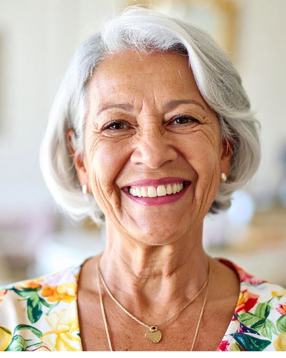 Patient admiring her new smile after getting dentures at Island Dentists