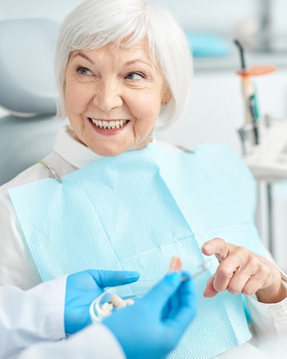 Senior patient smiling confidently after getting new dentures at Island Dentists